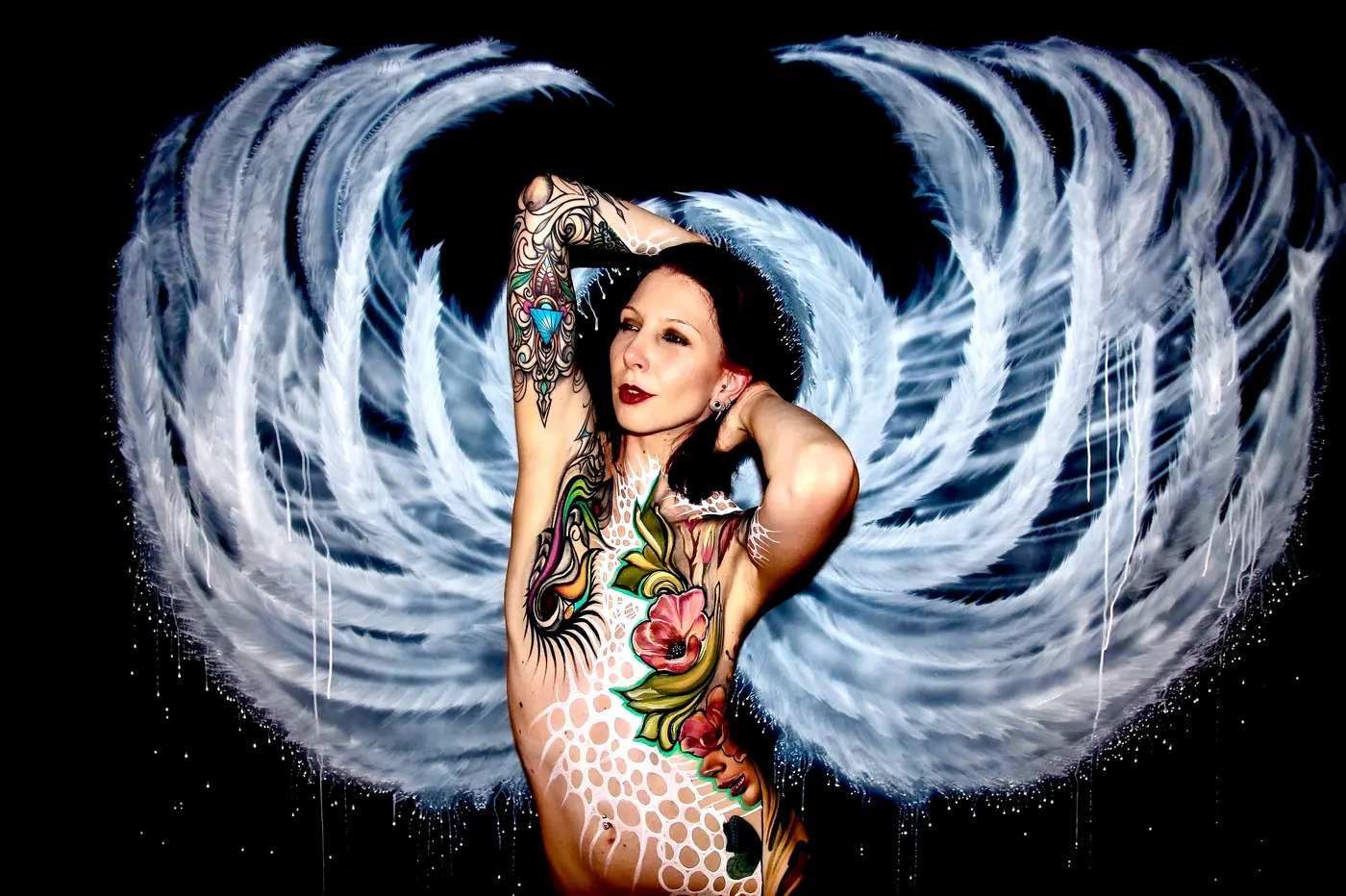 bodypaint met bloemen en geschilderde witte vleugels