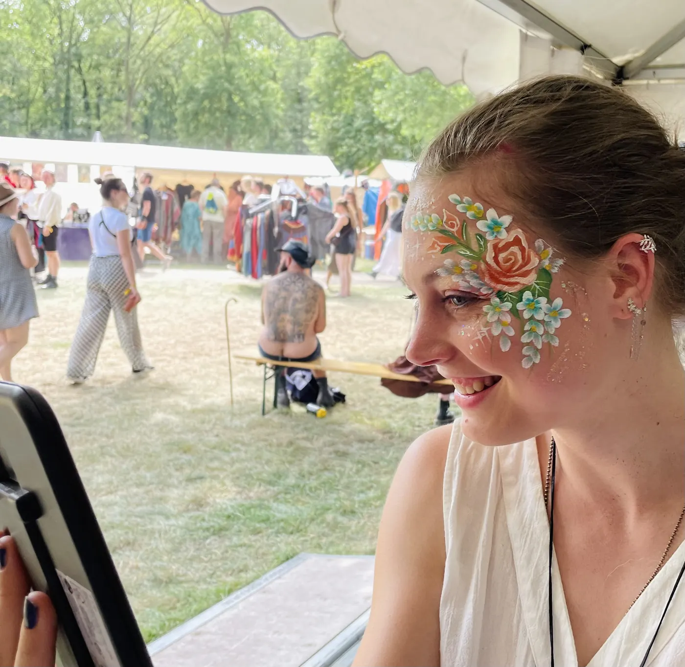 vrouw met oranje roos en witte bloemen op wang