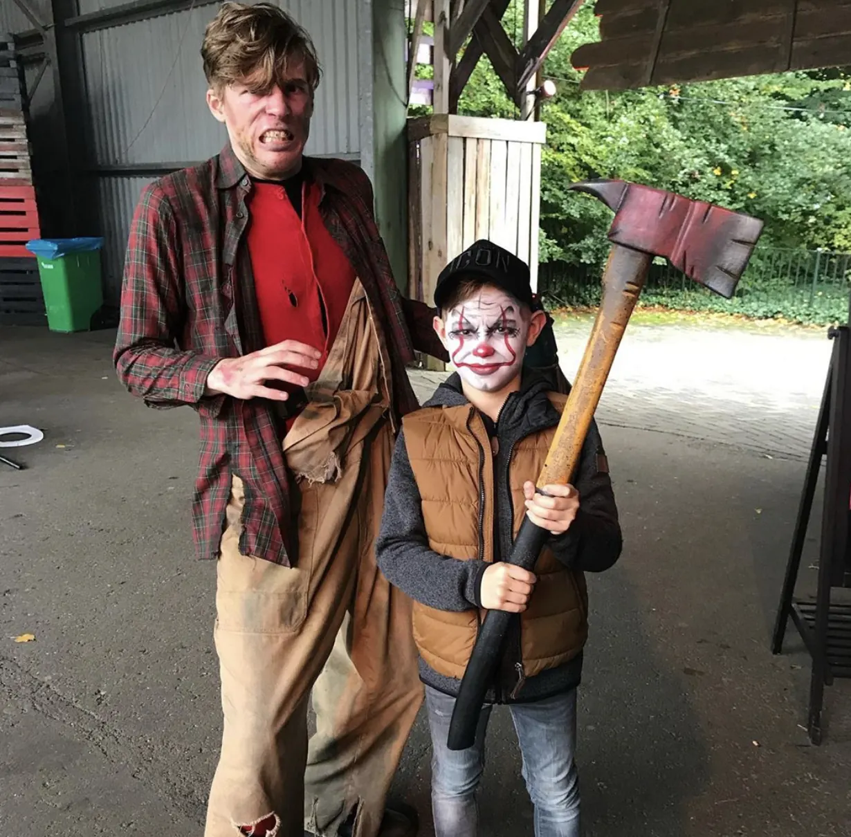 jongen met clownsschmink en bijl naast acteur