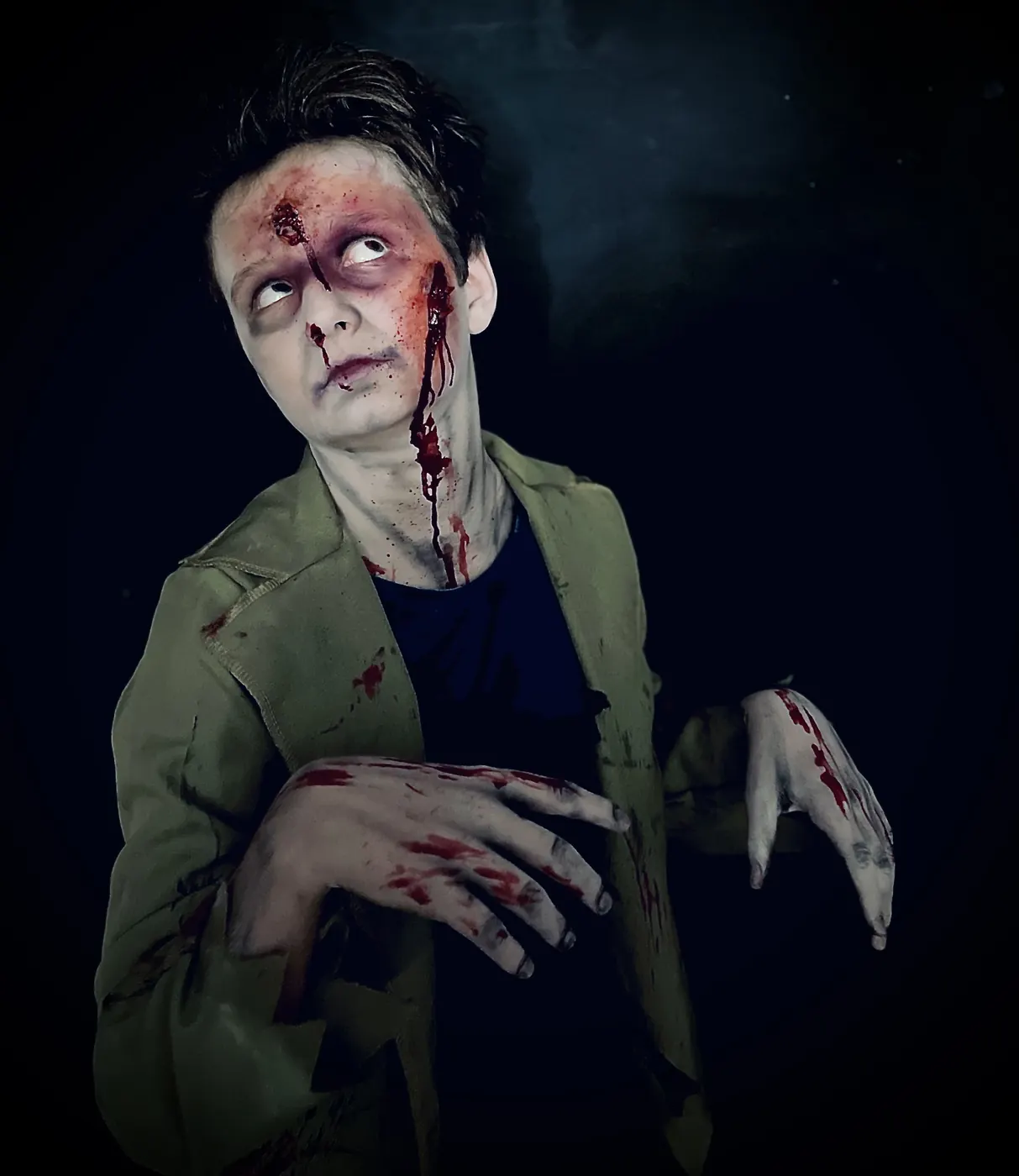 jongen met zombieschmink, bloed en witte lenzen