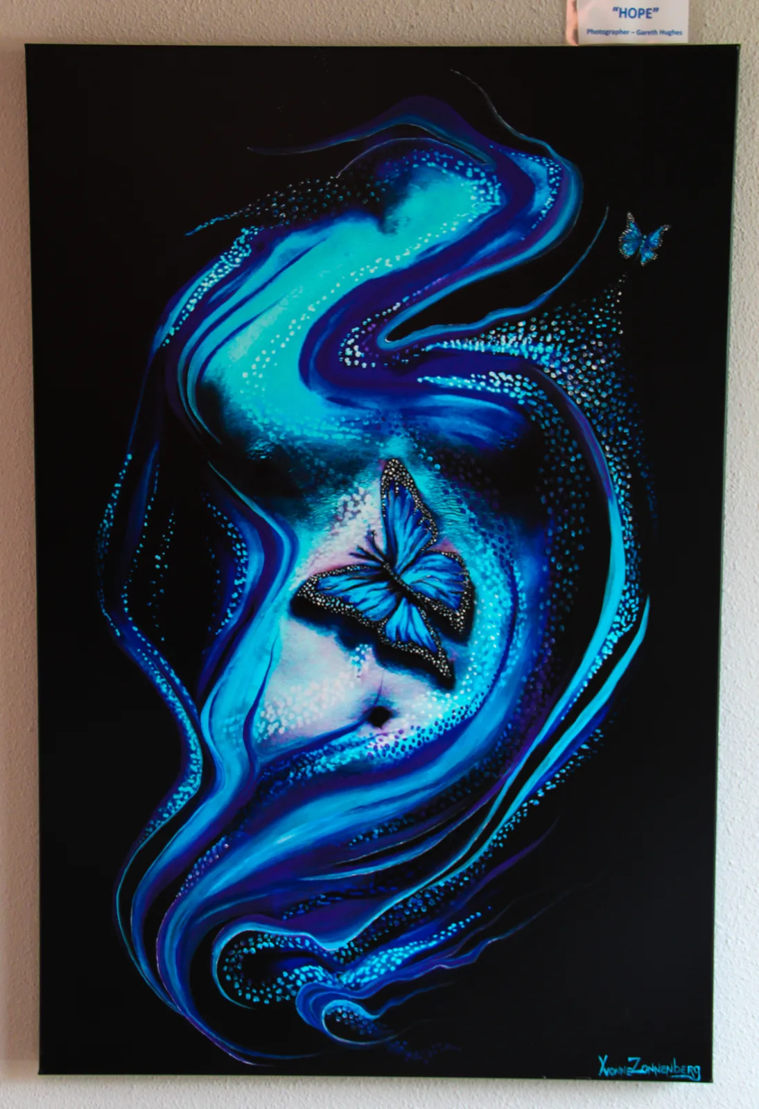 blauw kunstwerk van gezicht met vlinder