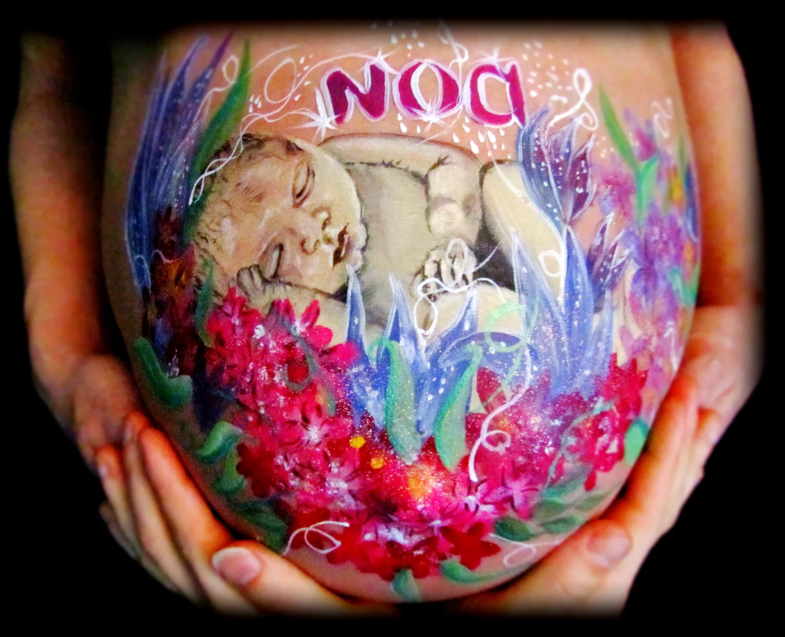 zwangere buik met slapende baby tussen bloemen