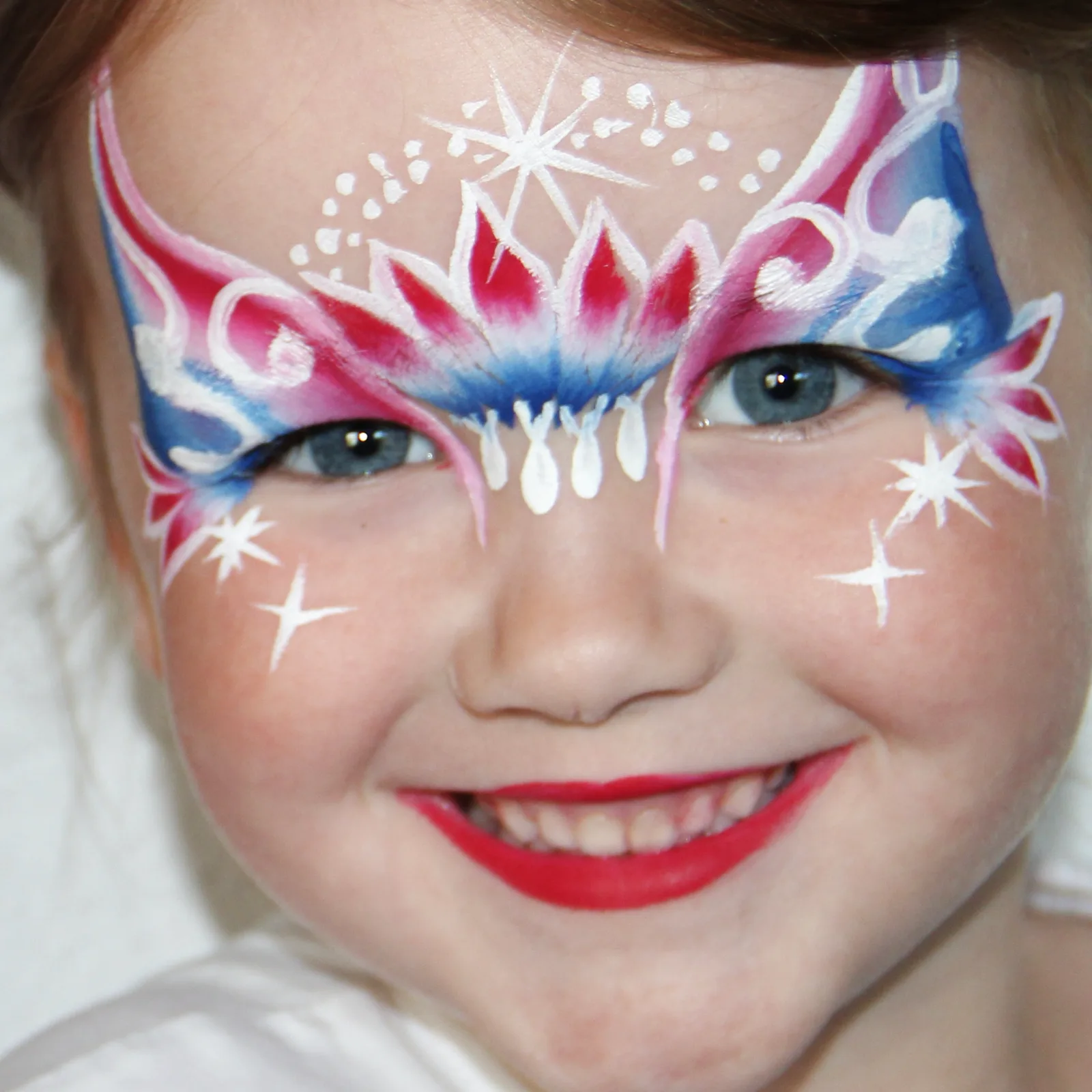 meisje met roze blauwe vlindermasker rond ogen