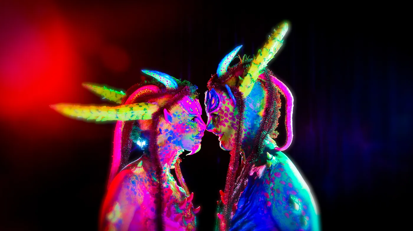twee bodypaint wezens met hoorns in neonkleuren